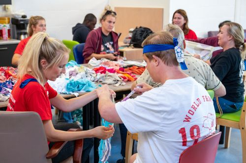 Samen met bewoners slingers maken voor het buitentheater